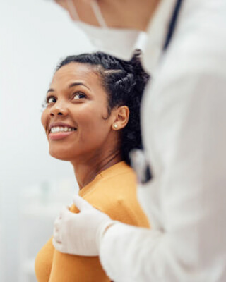 Image of a doctor holding a lady patient shoulder from back