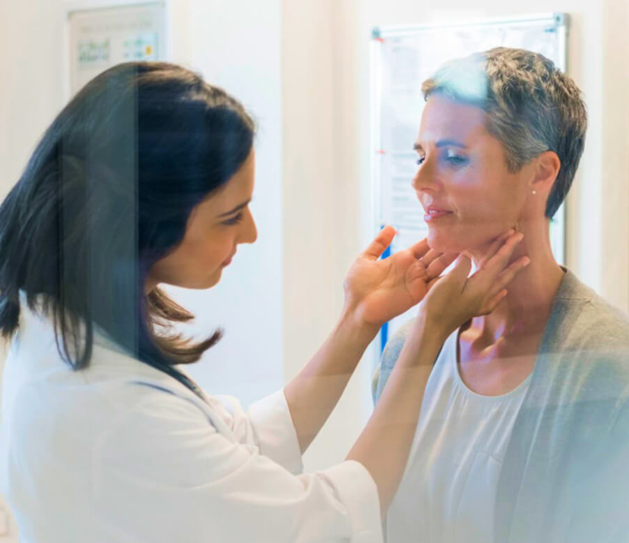 Image of a lady doctor touching and checking her lady patient's neck