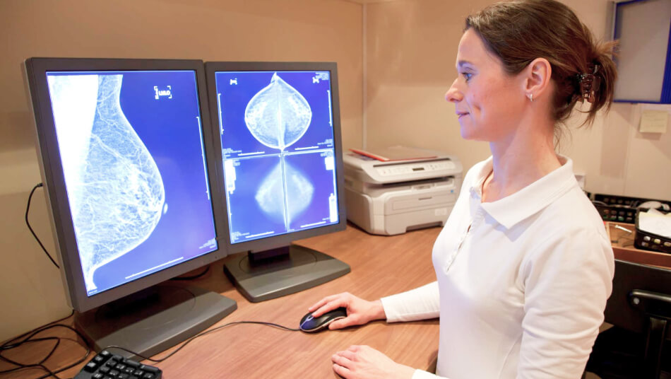 A female lab technicial checking digital mammography on computer