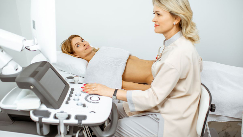 A lab technician scanning a woman patient and checking in computer