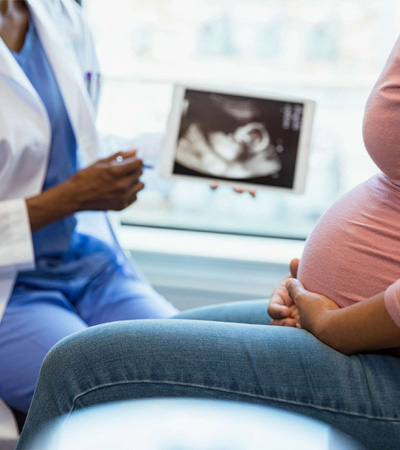 Image of a lady doctor explaing a pregnant patient with her scan report