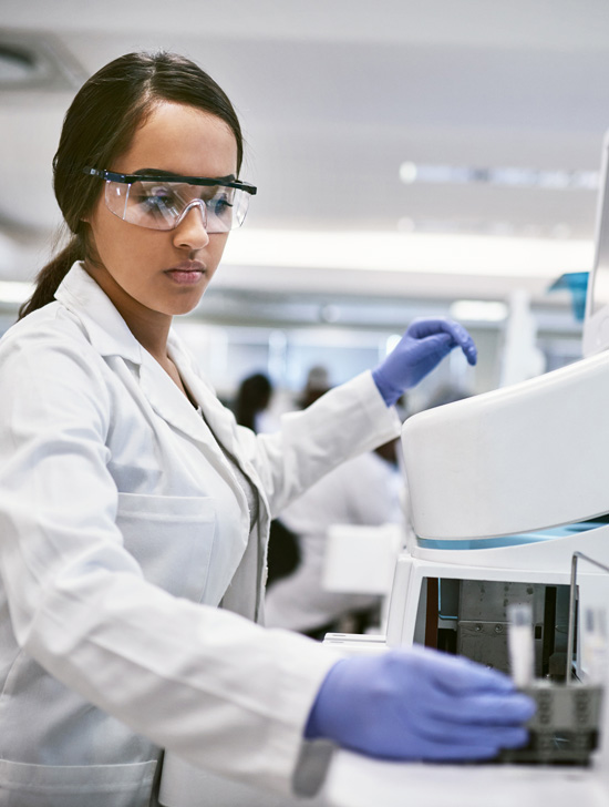 A lab technician working with a health scan machine